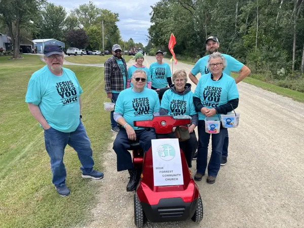 Church members in matching teal t-shirts gathered outdoors